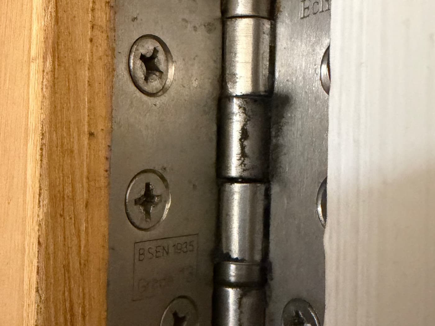 Ball-bearing hinge stamped BS EN 1935 Grade 13 on a fire door