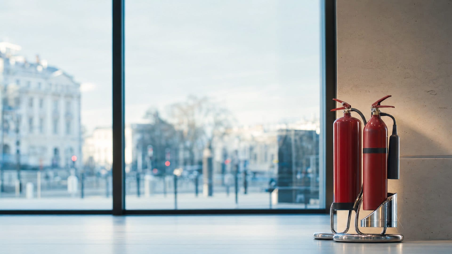Illustrative: water and CO2 extinguishers on a stand in an office lobby